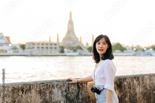 Portrait young beautiful asian woman smiling while travel at Wat Arun sunset view point, Bangkok, Thailand.