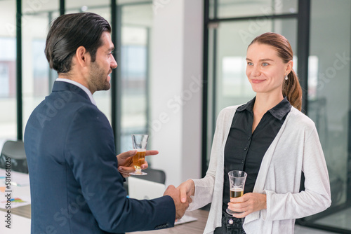 Corporate co-workers having drinks after meeting, People clinking glasses with sparkling wine indoors, Business people celebrating inside modern office.