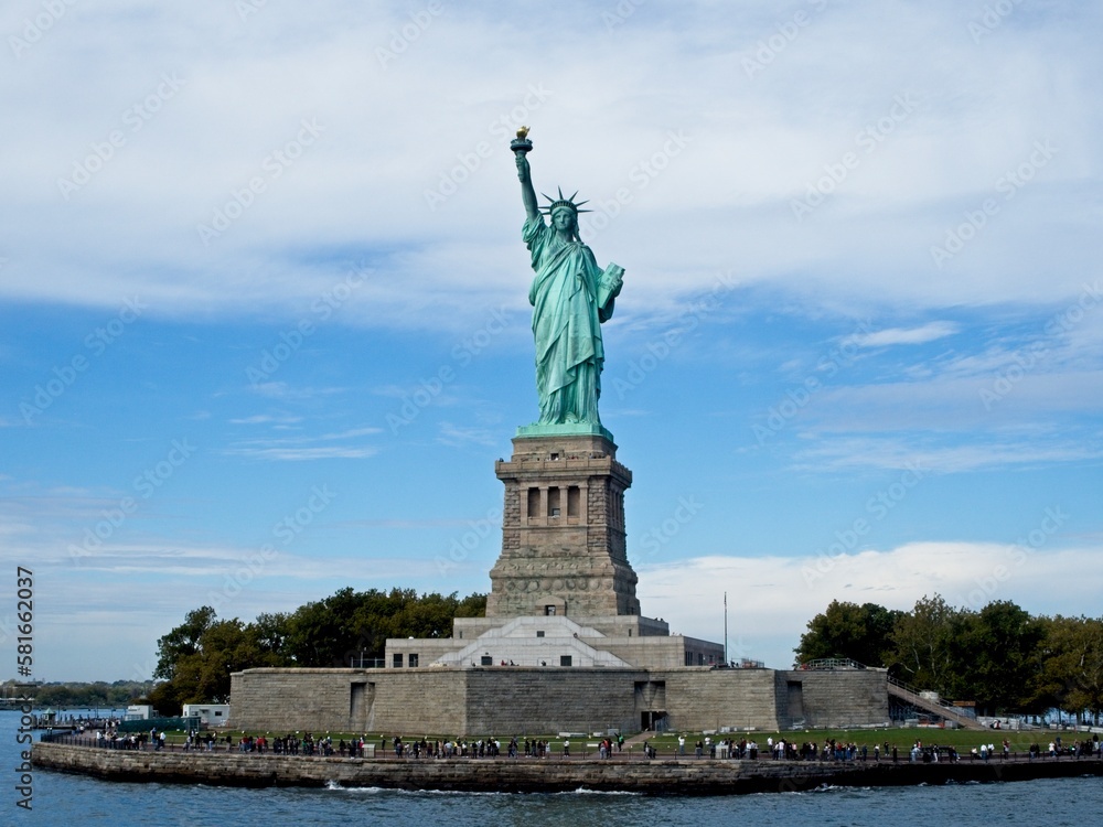 The Statue of Liberty sits on Liberty Island in the New York Harbor. It was once a beacon of hope for immigrants arriving by steamship into the United States