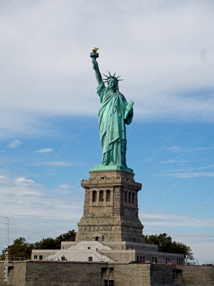Obraz premium The Statue of Liberty sits on Liberty Island in the New York Harbor. It was once a beacon of hope for immigrants arriving by steamship into the United States