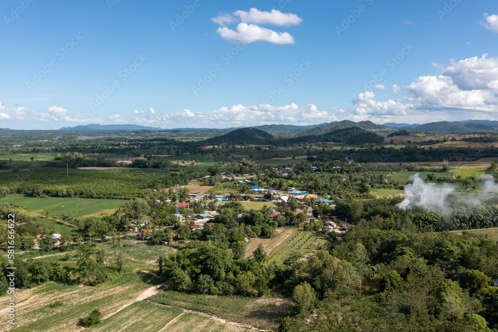 The aerial picture of Hui Kha Khaeng atmosphere, green forest and mountains, in Tak province, Thailand. The enormous wildlife sanctuary environment with sunlight and clouds on the blue sky.