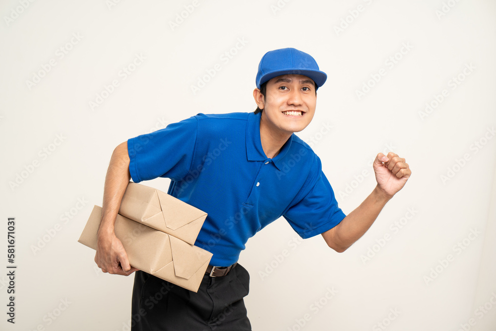 Asian man in blue uniform standing holding box parcel cardboard and smartphone on isolated white background. Male service worker with cell phone. Delivery courier shipping service Asian man in blue uniform standing holding box parcel cardboard and smartphone on isolated white background. Male service worker with cell phone. Delivery courier shipping service
