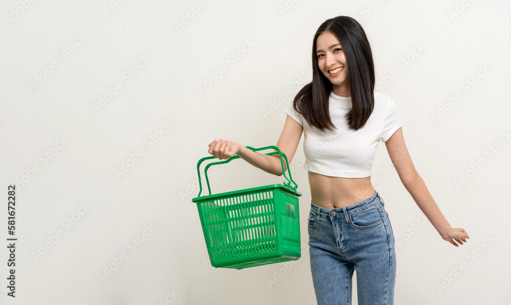 Happy beautiful woman holding shopping basket. Portrait beautiful asian female in fashion style standing pose on isolated background. Young asian woman shopping at online market application Happy beautiful woman holding shopping basket. Portrait beautiful asian female in fashion style standing pose on isolated background. Young asian woman shopping at online market application