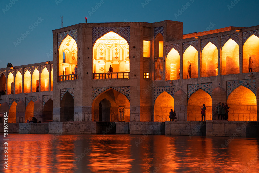 Isfahan, Iran - 15th june, 2022: Old Khajoo bridge at night, across the Zayandeh River in Isfahan, Iran.