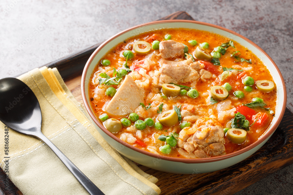 Asopao de Pollo this comforting Puerto Rican chicken and rice gumbo dish is loved throughout the Caribbean closeup on the bowl on the table. Horizontal Asopao de Pollo this comforting Puerto Rican chicken and rice gumbo dish is loved throughout the Caribbean closeup on the bowl on the table. Horizontal