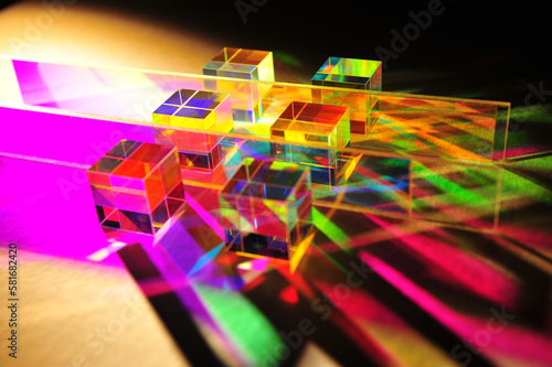 Foto Artistic dispersion of artificial light, dichroic square glass cube and horizontal stripe scattering narrow beam of light into several colours of spectrum on texture white paper background