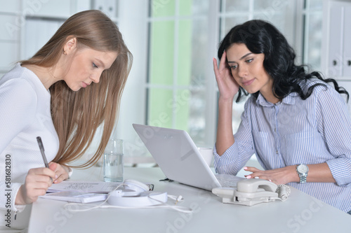 Young businesswomen discussing something in modern office