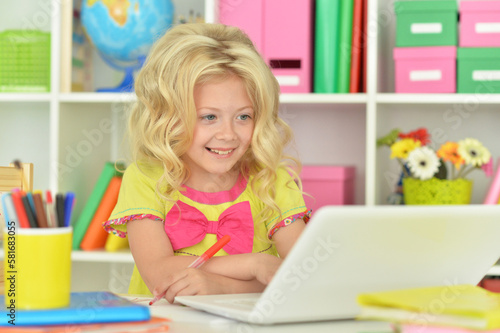 girl using laptop at desk at home