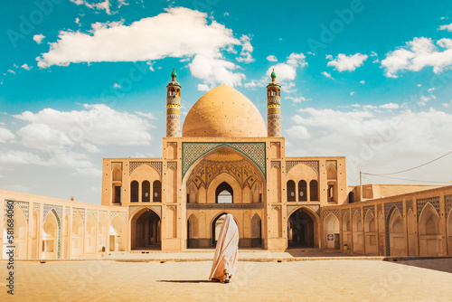 Kashan, Iran - 29th may, 2022: muslim woman pilgrim visit explore beautiful Agha Bozorg Mosque in sunny day photo