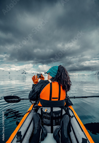 Female Kayaker Takes Picture of Beautiful Landscape On Calm Waters of Antarctica, Woman in Orange Life Vest