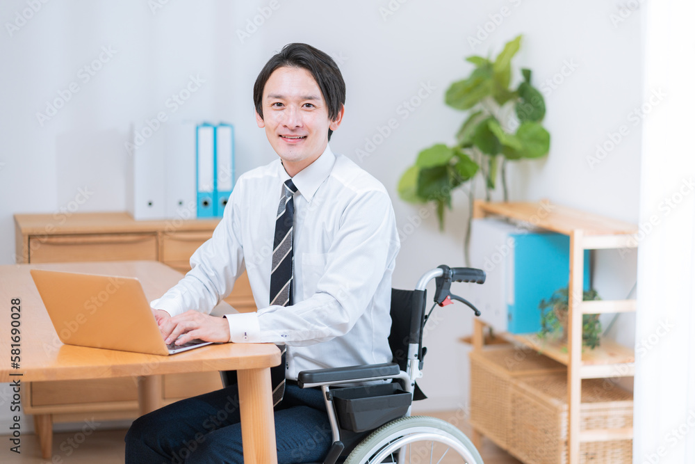 車椅子に座って仕事をするビジネスマン 車椅子に座って仕事をするビジネスマン