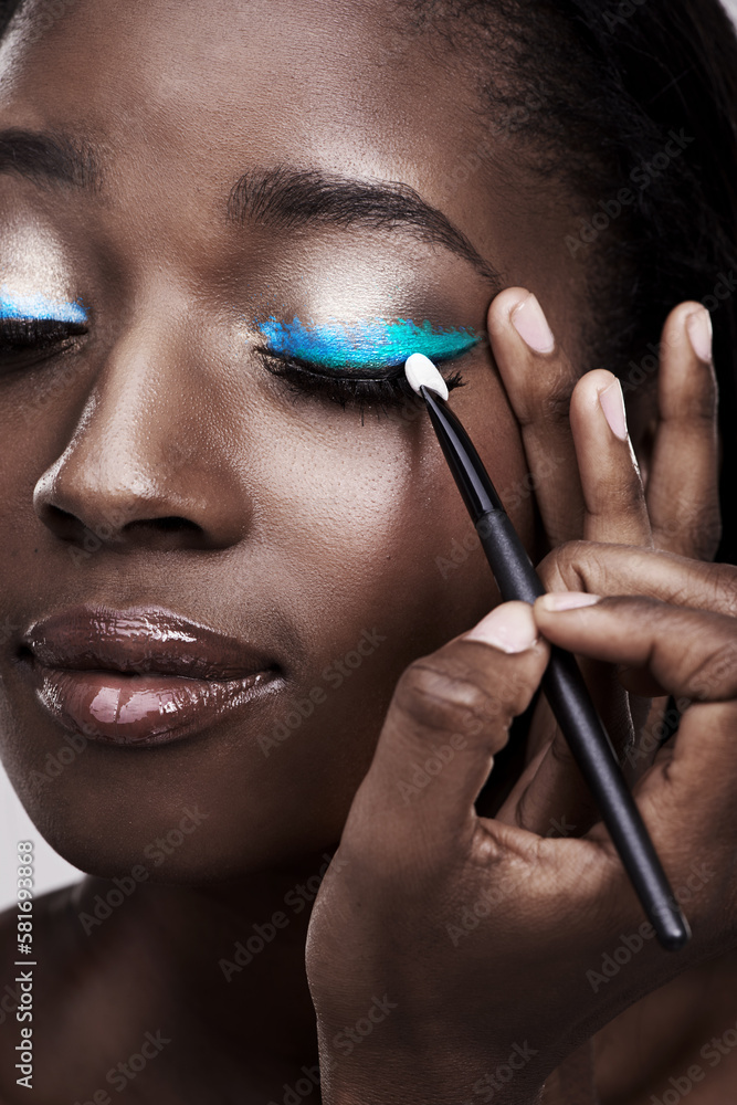 Color me beautiful. Studio shot of a beautiful young woman applying eye makeup.