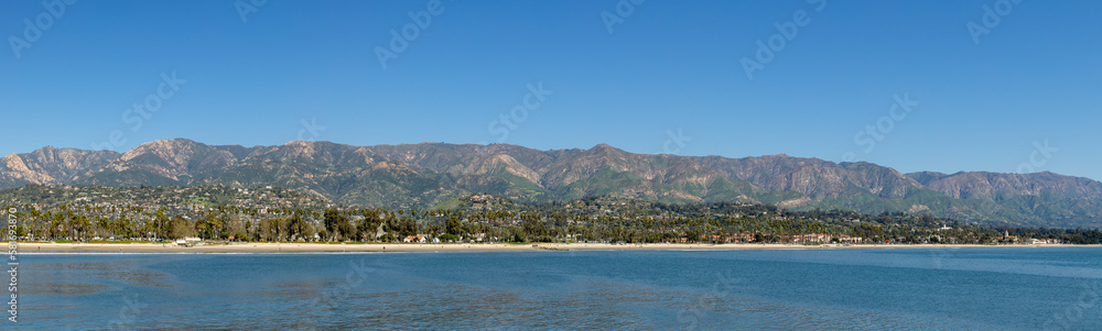 view to scenic beach with palm trees in Santa Barbara with houses at the hills, California