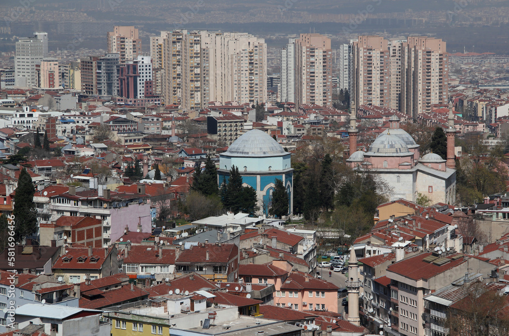 A panoramic view of the city of Bursa (Turkiye) with many mosques and a Green Tomb in the center of the photo	
