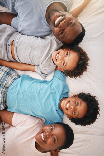 Happy black family, bed portrait and top view with happiness, kids and together with dad, mom and love. African children smile, parents and bedroom for bonding, care or support in morning for holiday