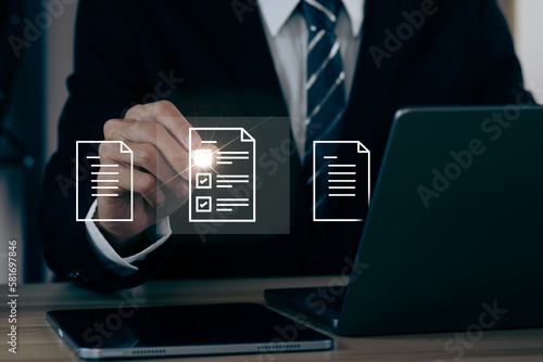 A businessman signs an electronic document on a digital document on a virtual notebook screen using a stylus pen. Paperless workplace idea, e-signing, electronic signature, document management.