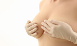 Women hands in rubber gloves cover naked breasts