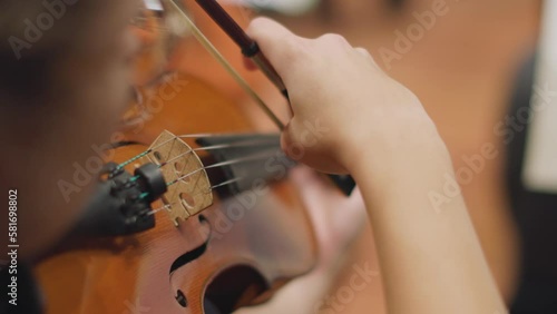 A slow motion video of a musician playing pizzicato on a violin during a classical symphony orchestra concert