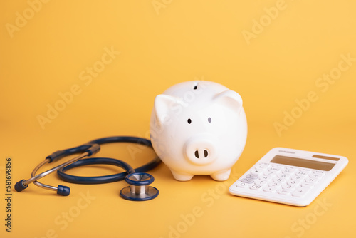 Financial for health concept, The idea of ​​saving money for healthcare, Close up stethoscope and white piggy bank on yellow color copy space. Health and finance concept