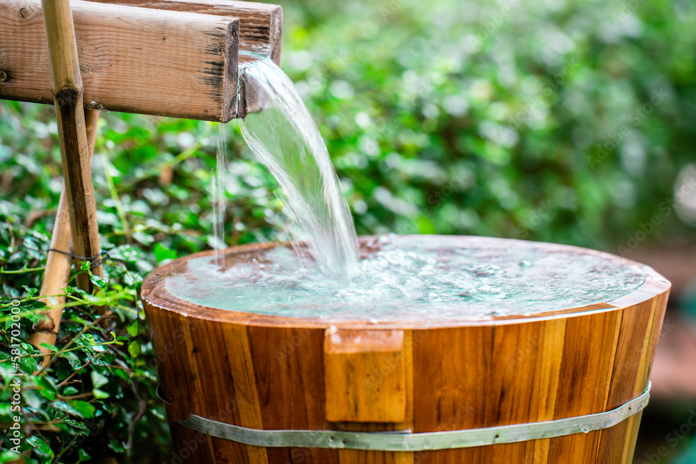 water-flowing-into-a-glass-wooden-barrels-for-natural-onsen-steam-hot