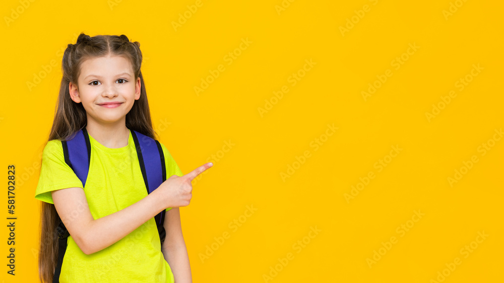 A schoolgirl with a backpack. A little girl with a satchel on her back. Supplementary education of the child. Educational, preparatory courses for school. Yellow isolated background. Copy space. A schoolgirl with a backpack. A little girl with a satchel on her back. Supplementary education of the child. Educational, preparatory courses for school. Yellow isolated background. Copy space.