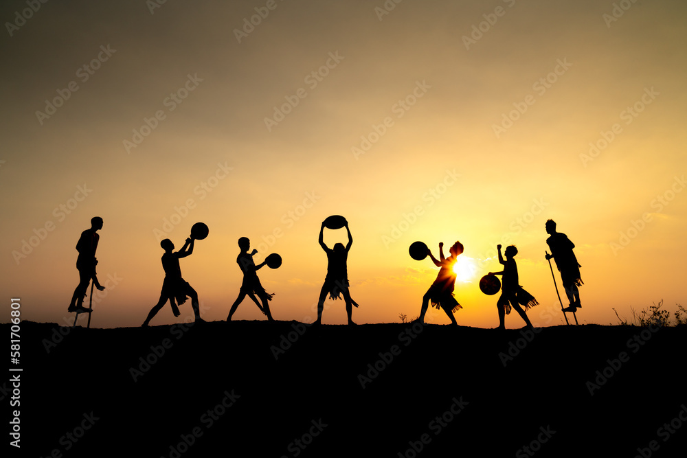 Silhouettes of Ede boys and girls performing their traditional dance during sunset in Pleiku town, Gia Lai province, Vietnam. Silhouettes of Ede boys and girls performing their traditional dance during sunset in Pleiku town, Gia Lai province, Vietnam.