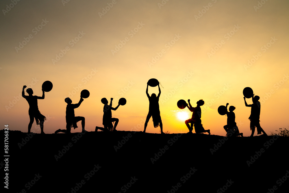 Silhouettes of Ede boys and girls performing their traditional dance during sunset in Pleiku town, Gia Lai province, Vietnam. Silhouettes of Ede boys and girls performing their traditional dance during sunset in Pleiku town, Gia Lai province, Vietnam.