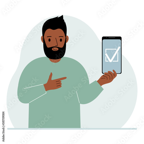 A man is holding a phone with a check mark on the screen. The concept of choice, voting or defence.