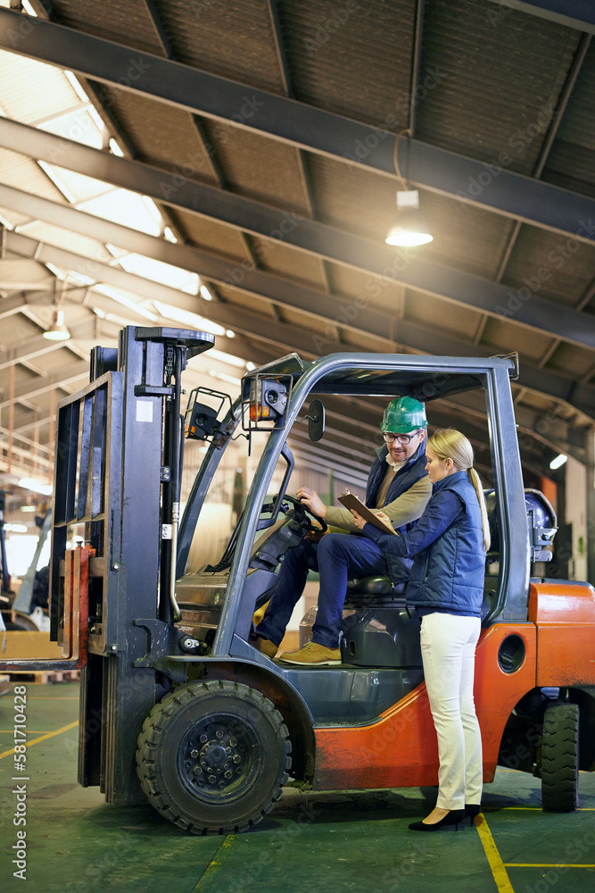 Lets get things moving around here. driver in a forklift and a manager on the factory floor.