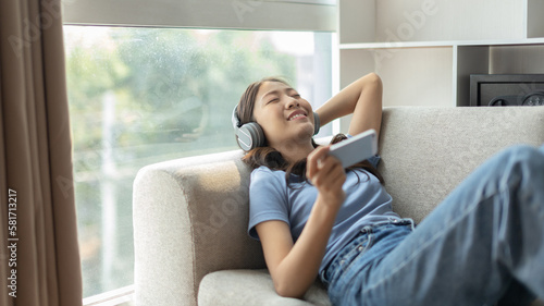 Woman happily listening to music on her favorite sofa in the living room, Relaxation time, Happy time, Feel good, Happy women resting at work after work is finished, Chill, Fatigue is eased.