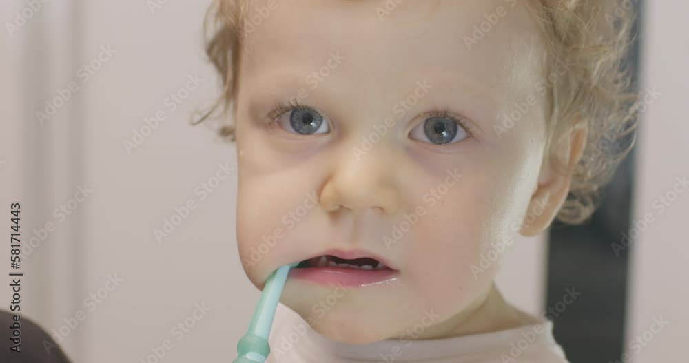 A small baby brushing teeth in the bathroom A small baby brushing teeth in the bathroom