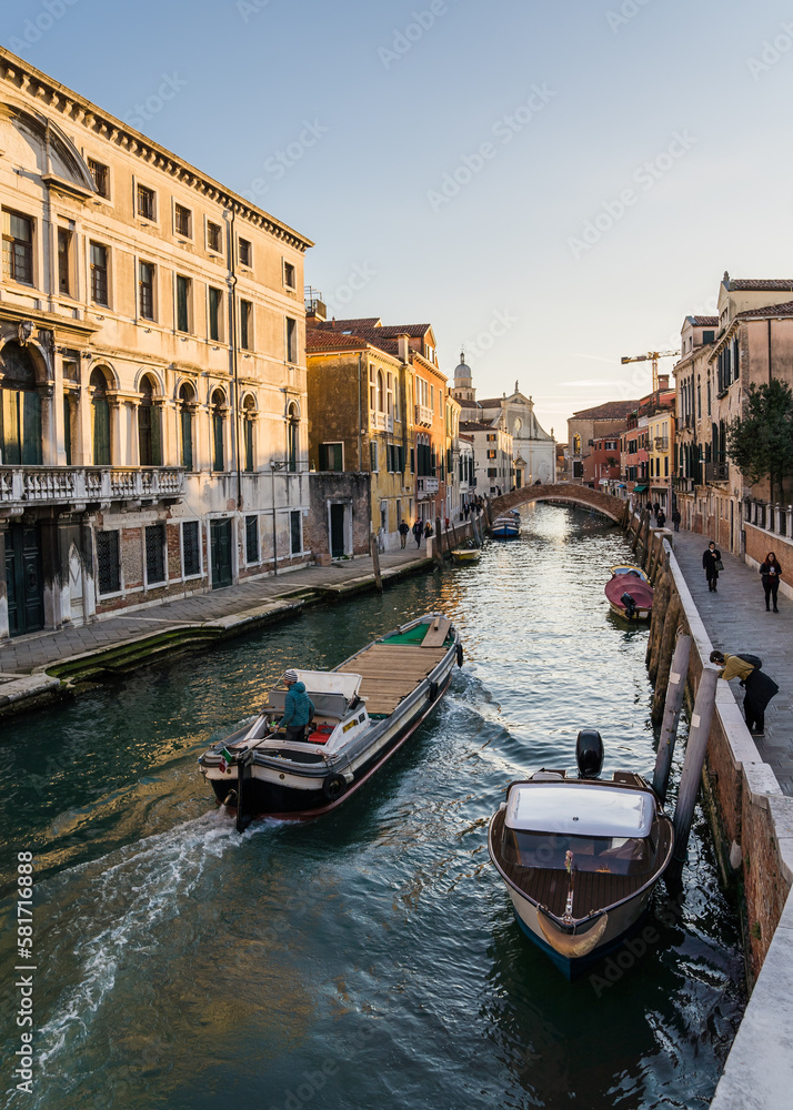 Canal in Venice, Italy and boat navigating passing by