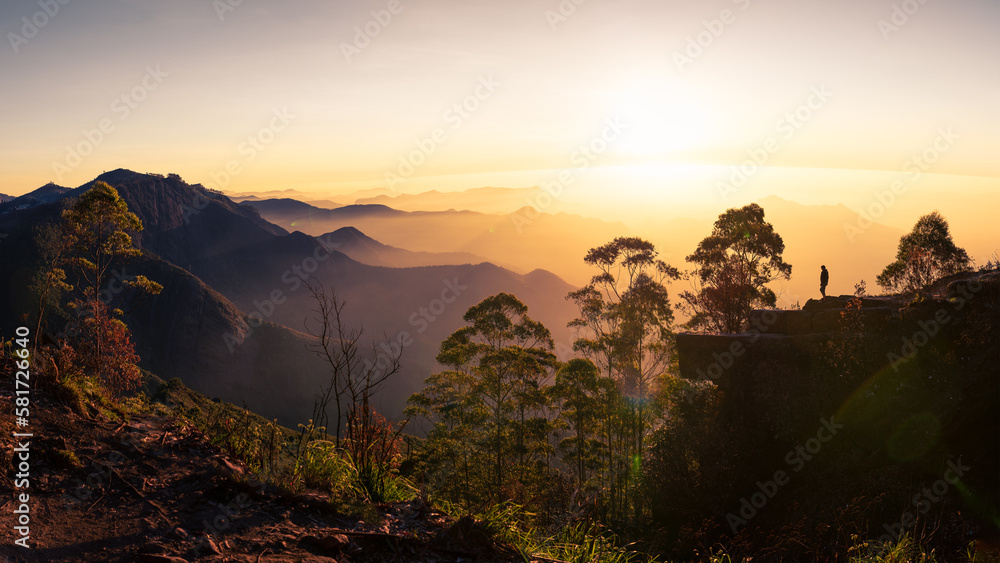 Silhouette of a woman watching the sunrise at Dolphin's nose in Kodaikanal, India