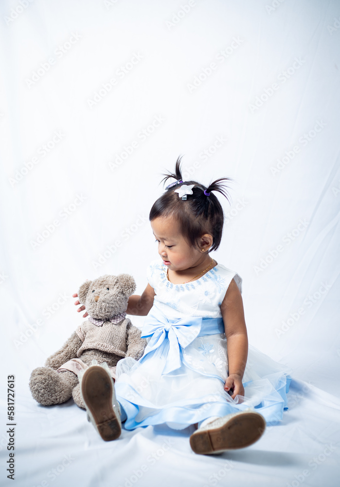 Little girl playing with her teddy beat isolated on white background. Little girl playing with her teddy beat isolated on white background.