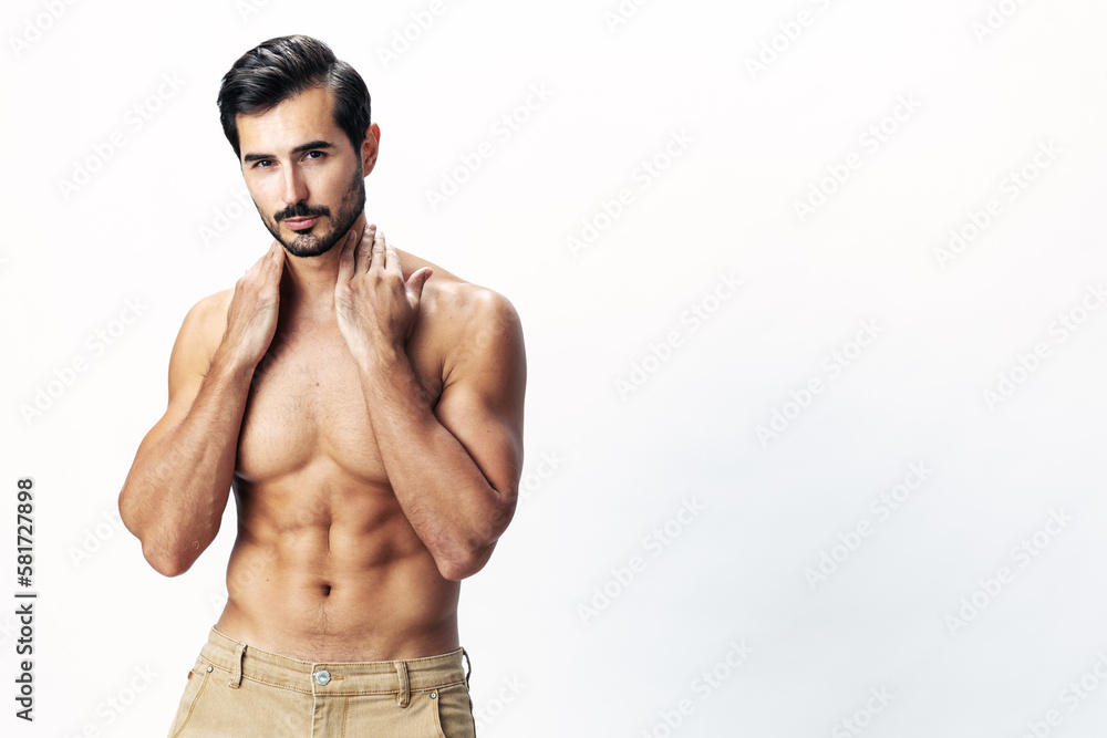 Fototapeta premium Man athlete model with a naked torso and six pack abs sporty inflated figure and tan on a white isolated background, fashionable clothing style, copy space, space for text