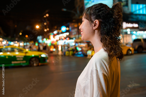 Beautiful young Asian tourist woman on vacation sightseeing and exploring at Khao San road at night in Bangkok city, Thailand, Holidays and traveling concept © tonefotografia