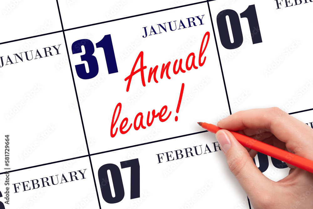Hand writing the text ANNUAL LEAVE and drawing the sun on the calendar date January 31 Hand writing the text ANNUAL LEAVE and drawing the sun on the calendar date January 31
