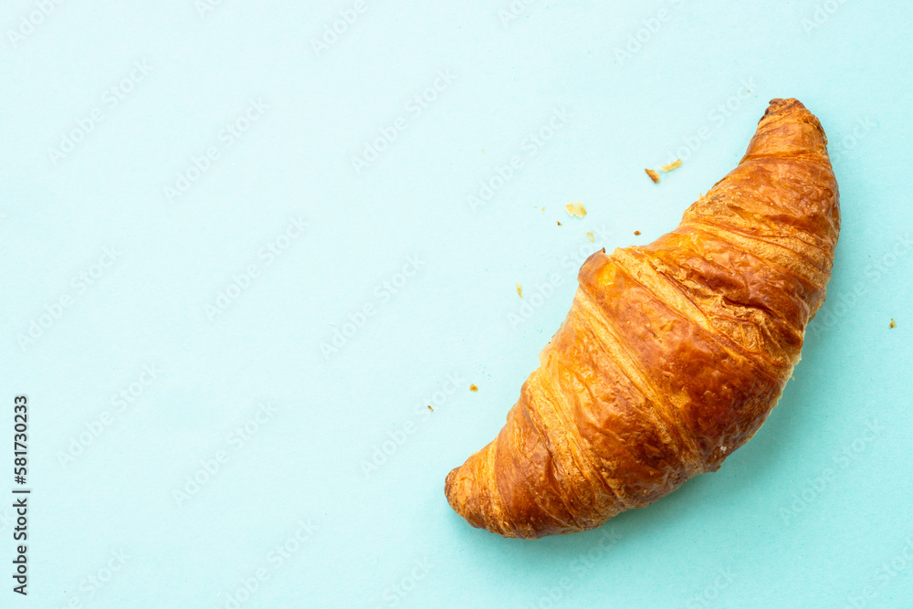 Croissant at blue background. French bakery. Flat lay.