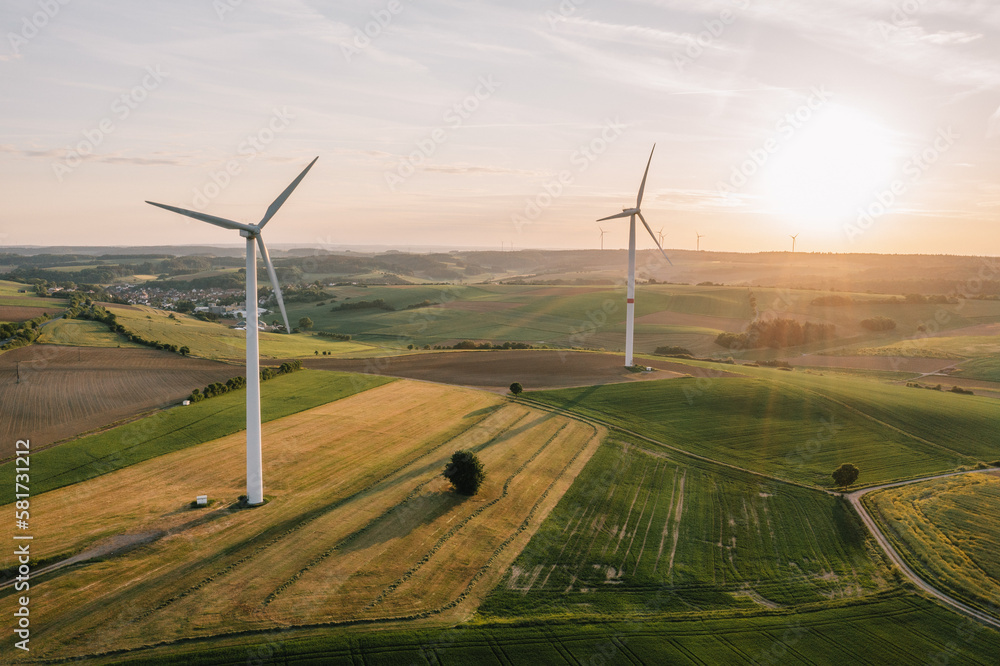 Obraz premium Windkraftanlagen bei Sonnenuntergang aufgenommen aus der Luft