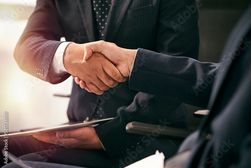 two asian business people shaking hands in office