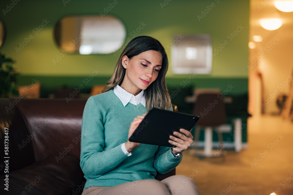 Businesswoman working over the digital tablet, sitting on a leather sofa, elegantly dressed. Businesswoman working over the digital tablet, sitting on a leather sofa, elegantly dressed.