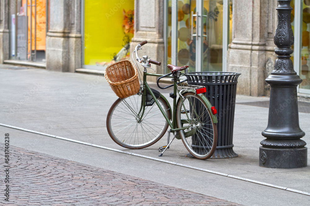 Old retro bicycle with wicker basket on the street. 