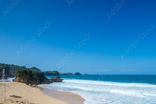 Fototapeta Naklejka Na Ścianę i Meble -  Tropical rocky beach with white sand and cliffs and blue sky with clouds on Sunny day. Summer tropical landscape, panoramic view. travel tourism wide panorama background concept. 