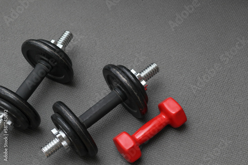 Fitness background. Dumbbells on a gray mat. Sports concept - gray mat, two black dumbbells 10 kg