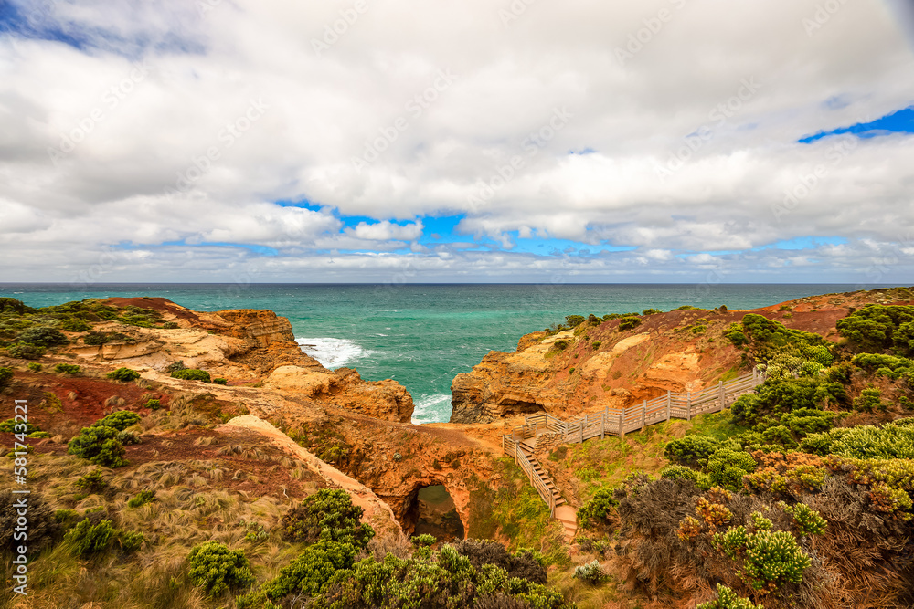 Landscape in Port Campbell National Park, Victoria Australia with footpath over wooden steps and landings to the Grotto a sinkhole with eroded view to ocean and Bass Strait