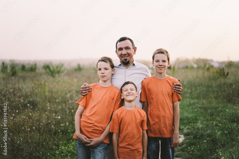 Happy Fathers day. Father with son are walking in the field. Dad hugs boy. The concept of Fathers day, relationships with children, care and love.