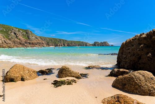 Porthcurno beach, picturesque retreat featuring turquoise waters, surrounding granite cliffs and golden sand. Cornwall, England UK
