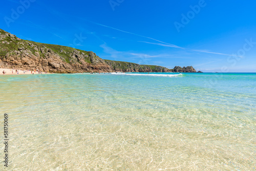 Porthcurno beach, picturesque retreat featuring turquoise waters, surrounding granite cliffs and golden sand. Cornwall, England UK photo