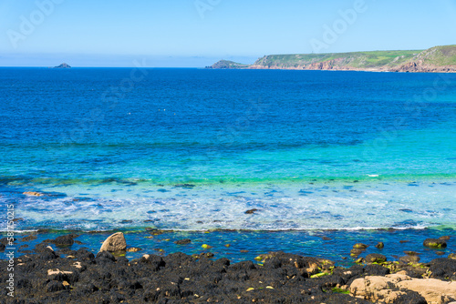 Sennen Cove beach and Cape Cornwall, beautiful bay with crystal clear turquoise water. Popular spot for surfing. England, UK. photo