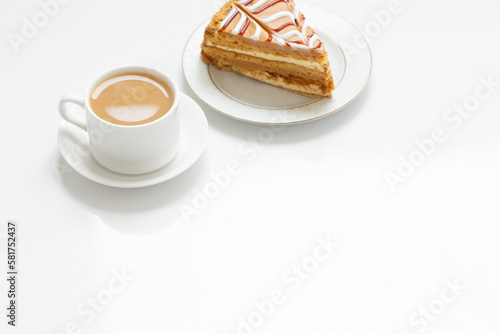 cup of coffee and piece of cake on white table